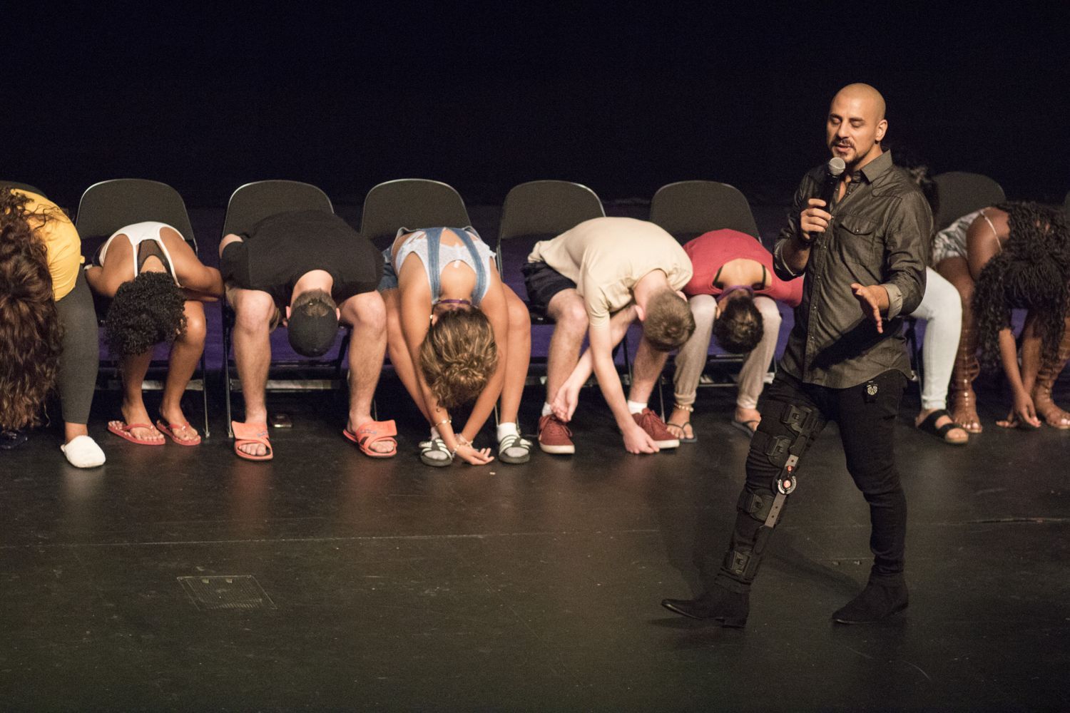 A full row of hypnotized volunteers on stage