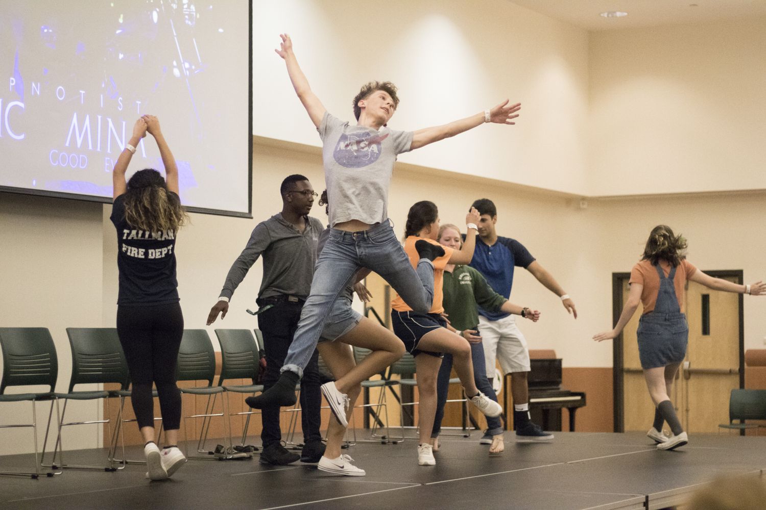 Student volunteers jumping on stage during a hypnosis show