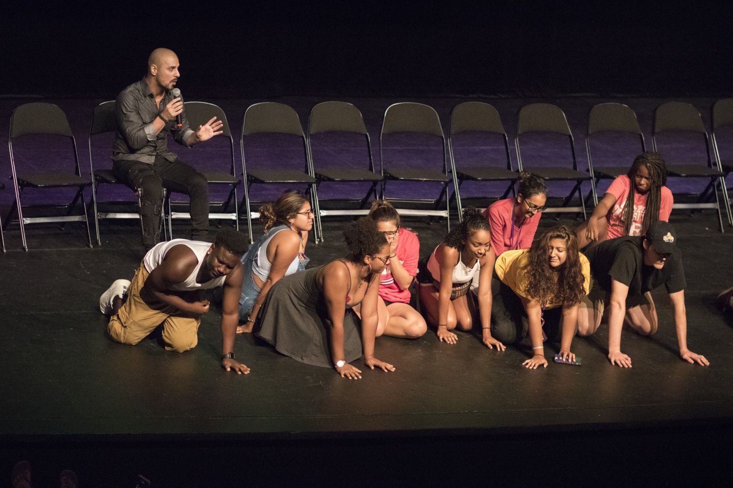 Student volunteers on stage during Eric Mina's hypnosis show