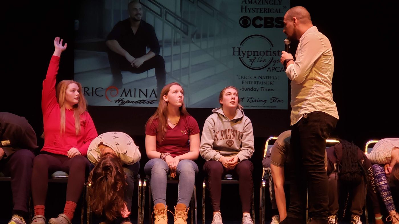 Eric Mina on stage with student volunteers