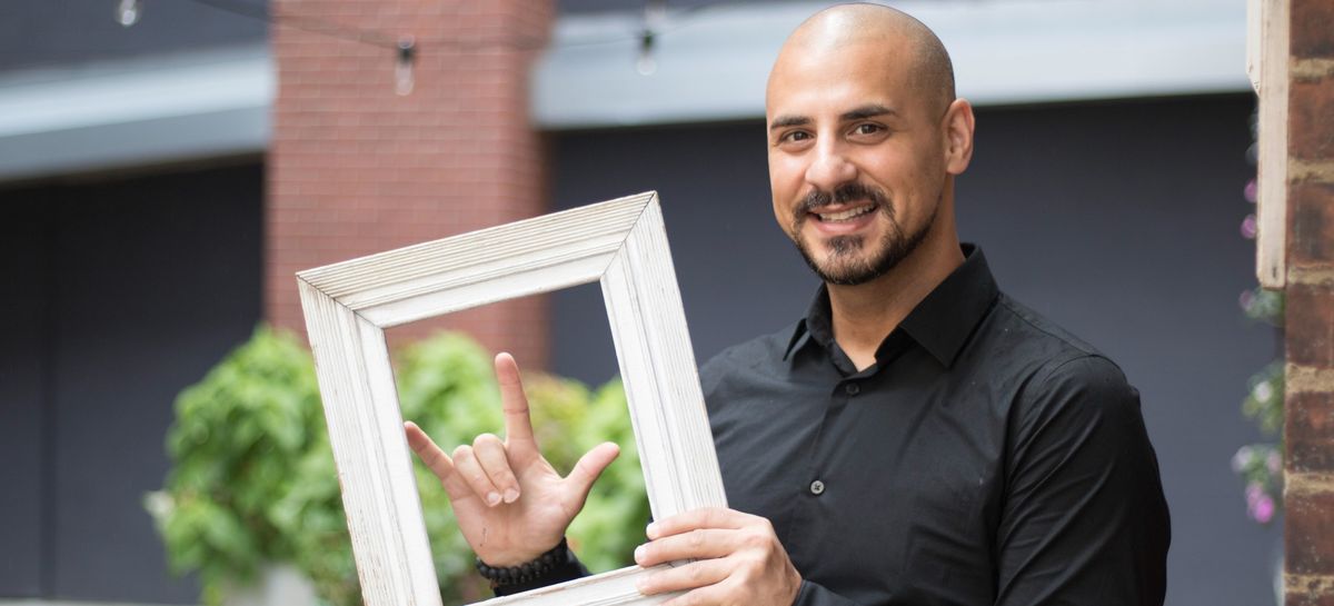 Eric Mina smiling and holding a picture frame