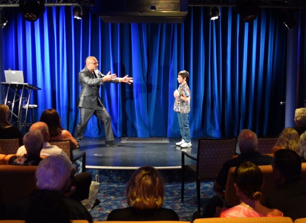 Eric Mina performing on stage for an adult audience