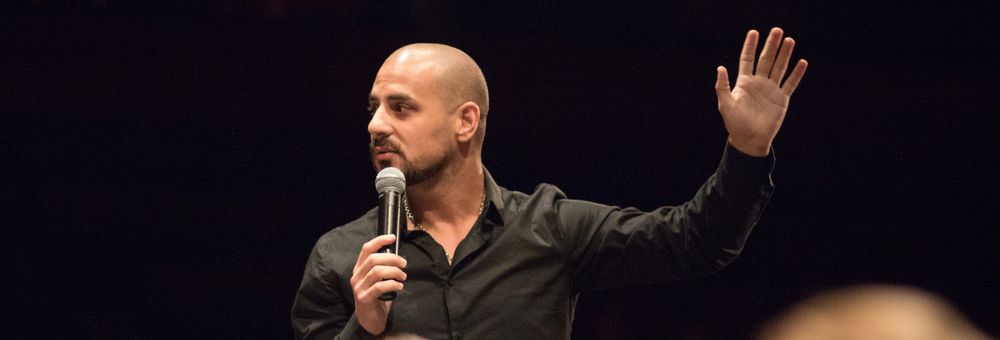 Eric Mina performing for a seated audience