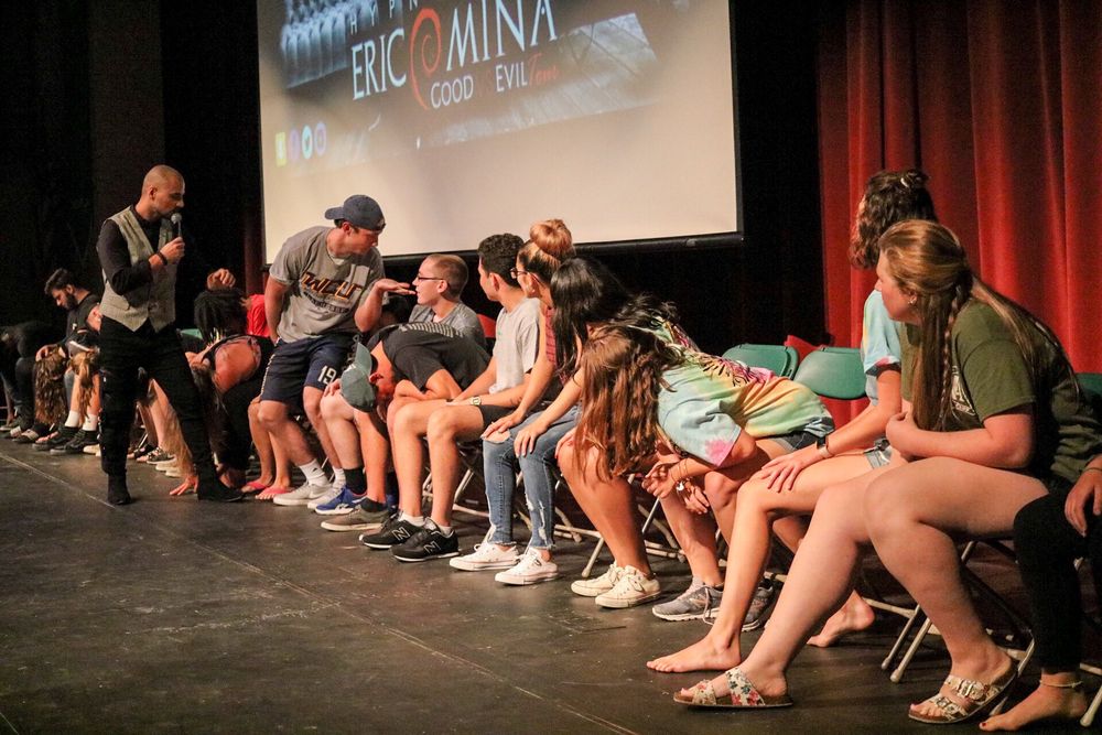 Row of hypnotized volunteers on stage