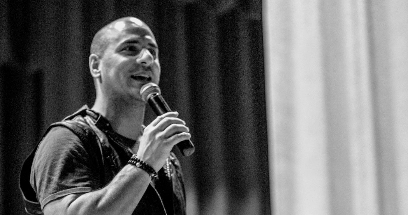 Eric Mina speaking into a microphone