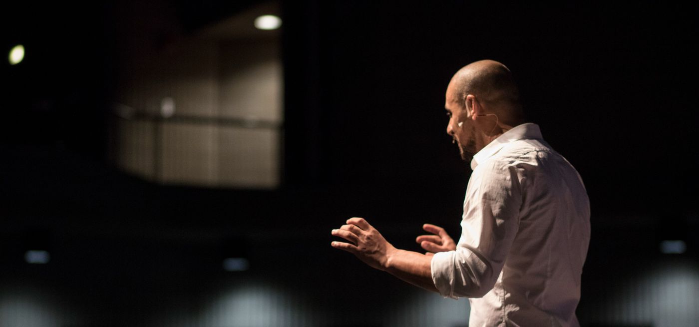 Eric Mina speaking on stage